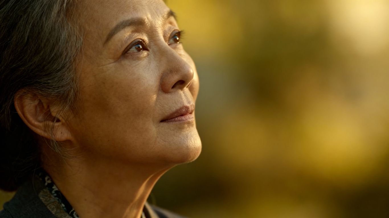 Mulher pensativa olhando para o horizonte.